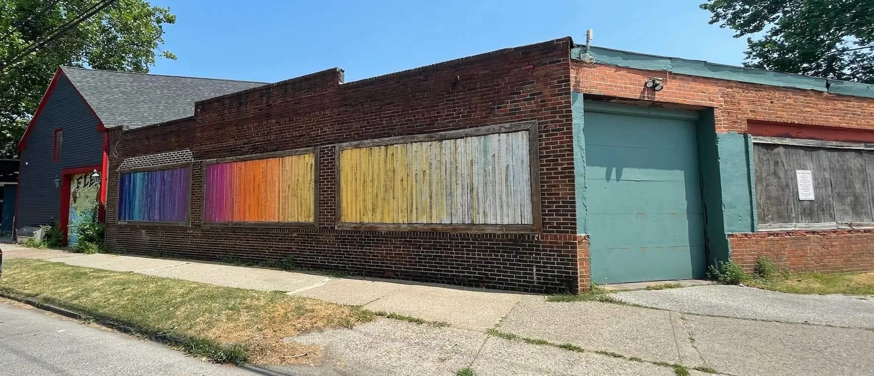 Bill Cotter's Chromatic Triptych — rainbow-painted panels across the Lemko Hall service station
